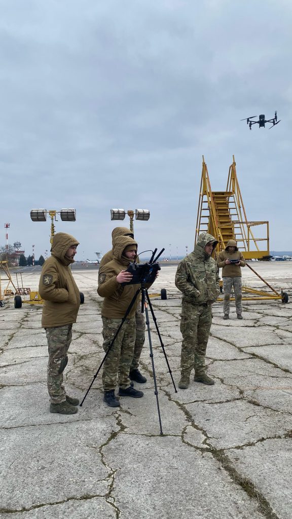 People in camouflage suits with IOD training robot Moldova.