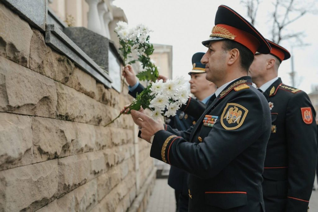 Policemen place white flowers in a wall.